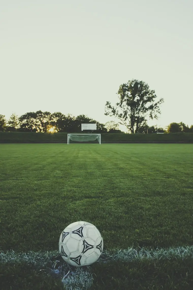 Bola num campo de futebol ao entardecer