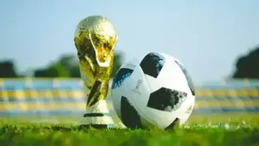 Troféu dourado ao lado de uma bola de futebol